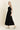 Woman wearing a black dress on a beige background