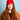 Person wearing a red beanie and brown jacket against a light blue background