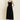 Woman wearing a black sleeveless dress against a beige background