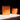 An orange candle on a white surface. 