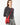 A model wearing a red purse on a grey background. 