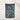 Navy blue towel with yellow floral pattern hanging on a line against a neutral background