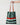 Striped tote bag with brown handle held by a hand on a light gray background