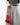 A model holding a red purse on a grey background. 