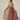 A model wearing a brown and yellow plain dress on a white background. 