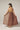A model wearing a brown and yellow plain dress on a white background. 