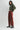 Woman wearing a green sweater and red pants on a white background