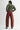 Person wearing a green sweater and red pants on a white background