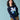 Person wearing a navy blue sweater with a pixelated design on a light blue background