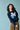 Person wearing a navy blue sweater with a pixelated design on a light blue background