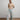 A model wearing a colorful sweater and jeans on a white background. 