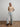 A model wearing a colorful sweater and jeans on a white background. 