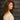 A model wearing a white sweater on a gray background.