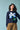 Person wearing a navy blue sweater with a pixelated flower design on a light blue background