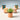 Small terracotta pots with plants on a light blue background. 