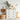 White dresser with wooden top in a room with wicker baskets and decorative items.