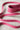A fuscia leather belt on a white surface. 