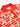 Detail of a red and cream patterned polo shirt on a white background. 