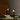 Two table lamps on a round wooden table with a chair in a room setting.