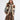 Handknit vest with horse motif and faux fur lining worn over a grey turtleneck paired with brown plaid pants on white background.