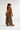 A model is shown from the back wearing a brown crewneck sweatshirt and wide-leg brown plaid trousers, paired with brown patterned loafers, against a plain white studio background.