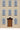 Close up of a cream colored cardigan showing blue and brown panes window details and a brown and light brown door.