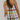 Person wearing a colorful checkered dress with a plain background