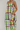 Person wearing a colorful striped dress against a plain background