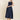 Woman wearing a navy dress on a beige background