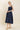 Woman wearing a navy dress on a beige background