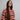 A model wearing a bright colored top on a grey background
