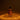 A clear glass bottle of dilo Satsuma Oud Eau de Parfum with amber liquid and a black spray cap, set against a dark brown background with warm golden light patterns on the surface below.