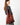 A model wearing a red shoulder bag on a grey background. 