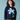 Person wearing a navy blue sweater with a pixelated flower design on a light blue background