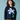 Person wearing a navy blue sweater with a pixelated flower design on a light blue background
