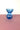 A blue vase on a pink surface with a white background