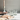 clear drinking glasses with floral etchings on a kitchen countertop next to a pink napkin and a lit candle