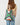 A model wearing a pleated multi color purse on a grey background. 