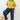A woman wearing a green sweater and black pants on a white background. 
