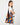 A model wearing a multi color shoulder bag on a white background. 