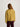Person wearing a mustard yellow quilted jacket on a white background