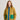 Person wearing a quilted jacket with green and blue accents on a plain background