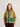 Person wearing a quilted jacket with green and blue accents on a plain background