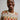 A model wearing a colorful sweater and on a white background. 