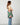 A model wearing a pleated multi color purse on a grey background. 