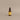 Room spray in a brown bottle with a yellow label on a grey background. 