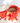 Bread in a red patterned cloth on a white surface with tomatoes.