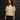 A model wearing a white sweater on a gray background.
