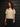 A model wearing a white sweater on a gray background.