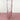 a clear pink vase on a pink surface with a white background